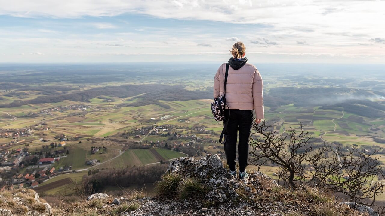 Woman looking into the distance on nature trail symbolizing personal growth and a fresh start.